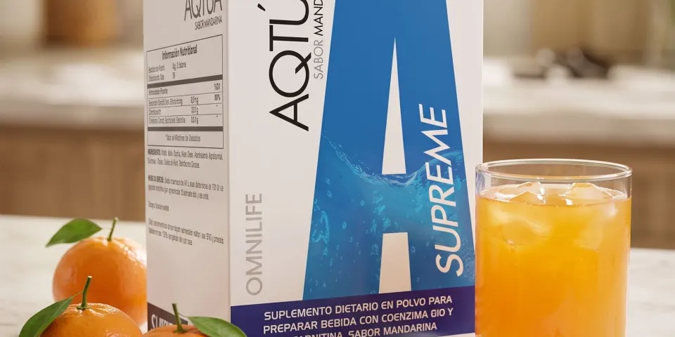 Caja de Aqtúa Supreme sabor mandarina junto a un vaso de bebida naranja y mandarinas