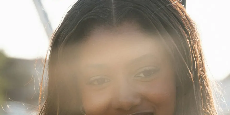 Mujer sonriendo con el cabello suelto al sol