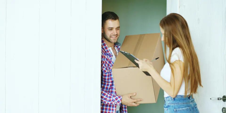 Mujer recibiendo un paquete en la puerta de su casa