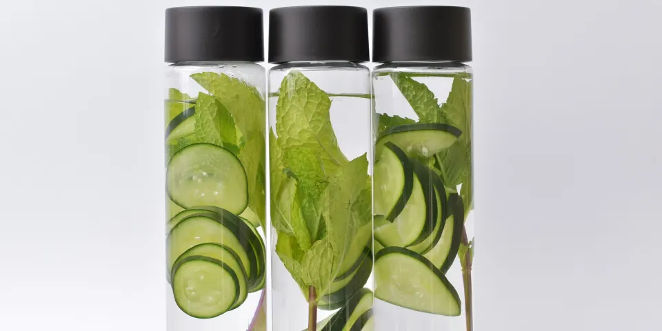 Botellas de agua con rodajas de pepino y hojas de menta