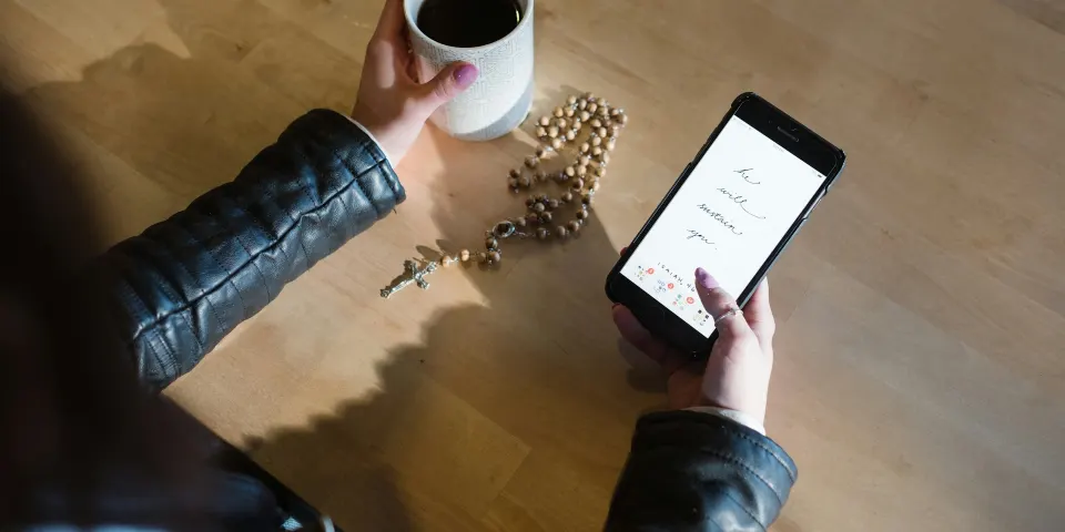 Persona revisando su pedido en el celular con una taza de café