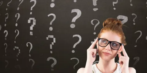 Mujer pensativa rodeada de signos de pregunta