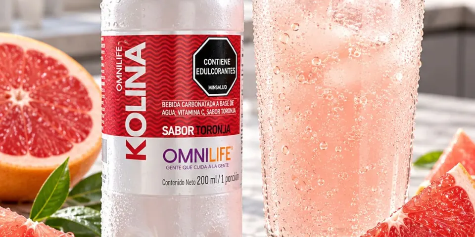 Botella de Kolina de Omnilife sabor toronja junto a un vaso con hielo