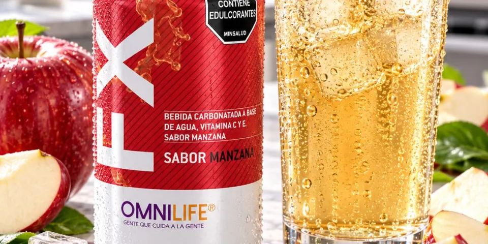 Lata de Omnilife FX sabor manzana junto a un vaso con hielo y manzanas