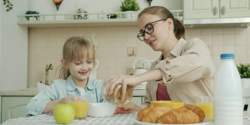 Madre e hija desayunando juntas en la cocina