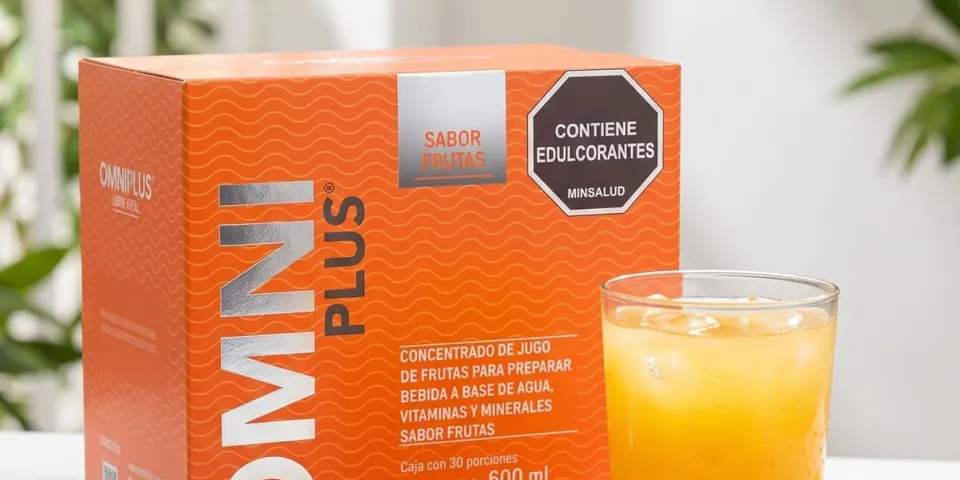 Caja de Omniplus sabor frutas junto a un vaso de bebida naranja y frutas