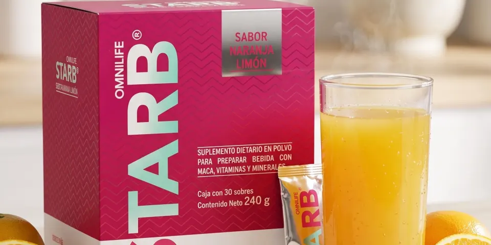 Caja de Starb sabor naranja limón junto a un vaso de jugo y frutas cítricas