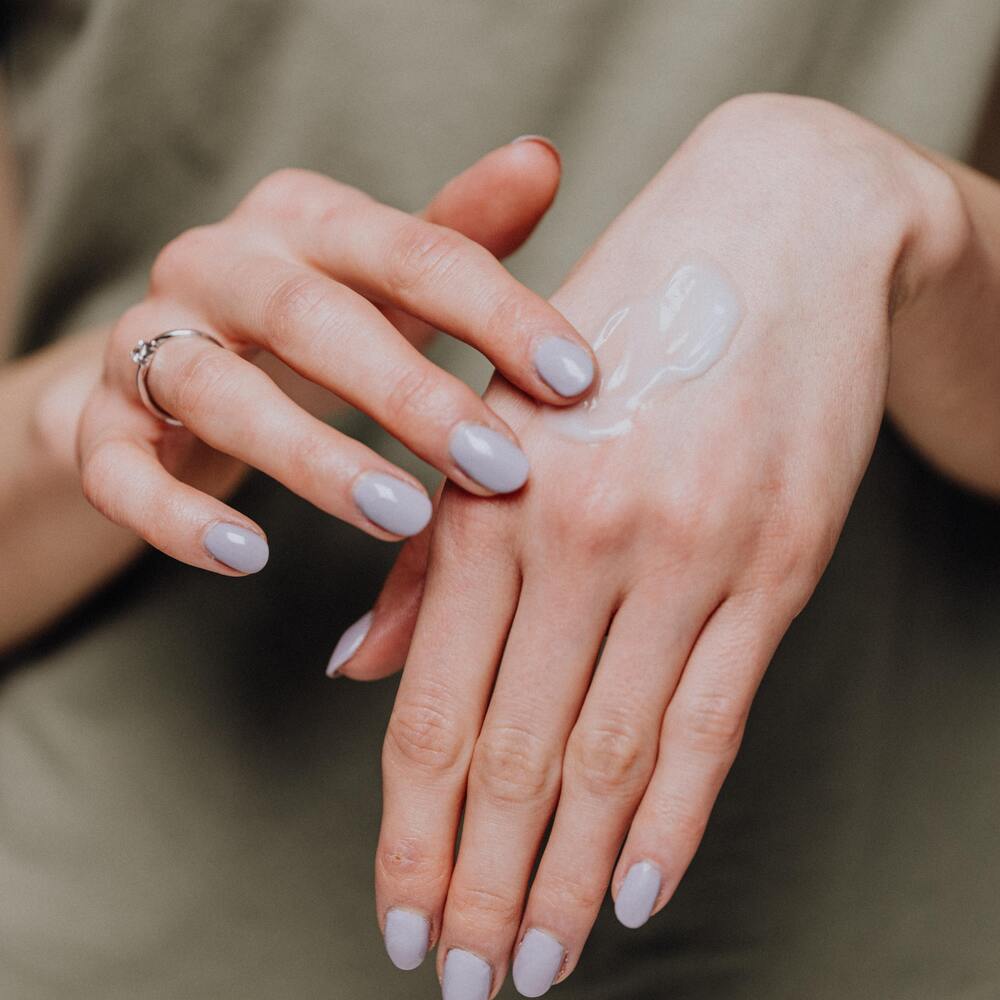 mujer aplicándose crema para la piel contra las manchas